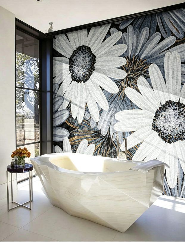 Oversized white daisy mosaic feature wall behind a sculptural marble bathtub in a modern bathroom